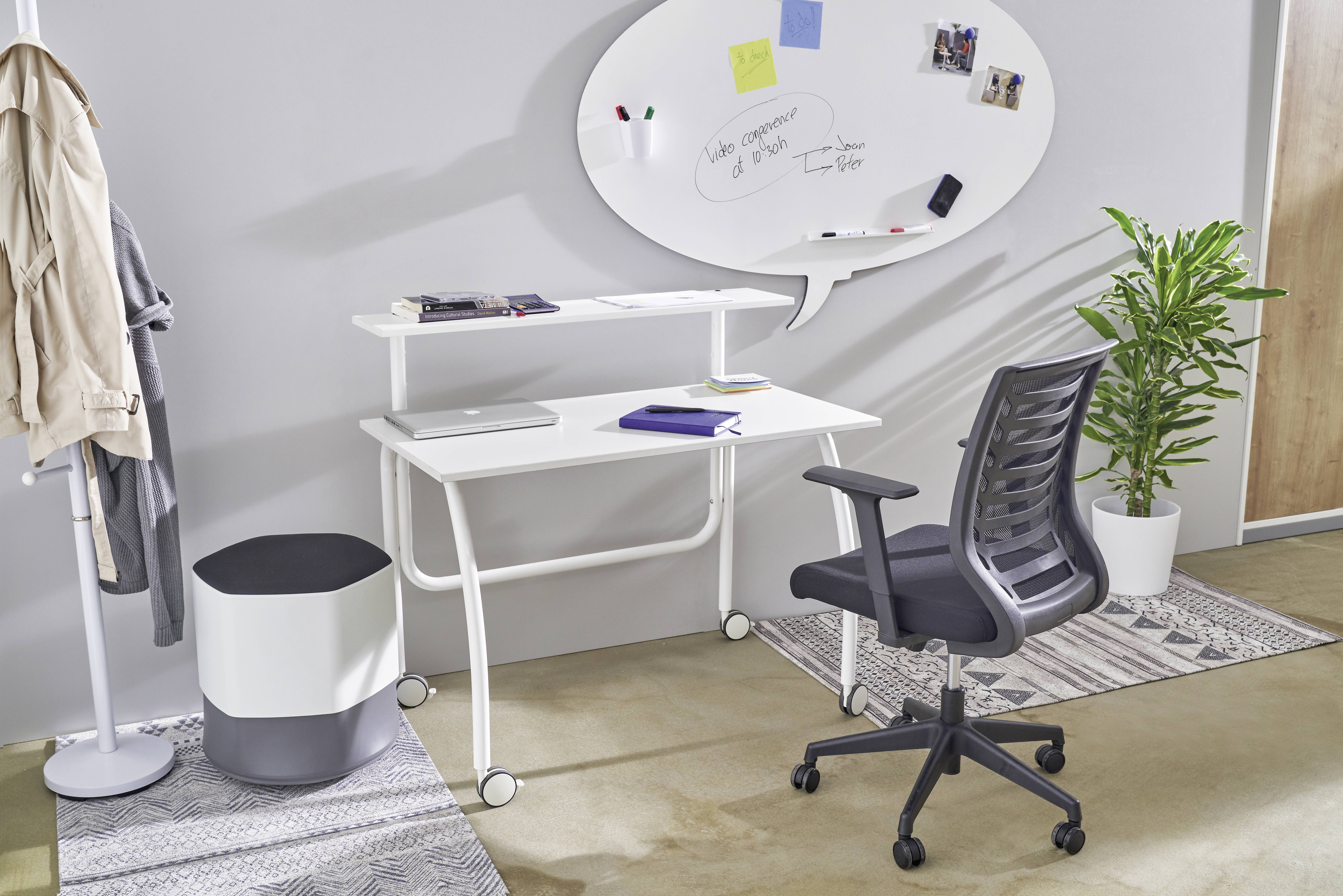 Moderner Arbeitsplatz mit weißem Schreibtisch, schwarzem Bürostuhl, Magnettafel an der Wand, Pflanzen und Dekor im Hintergrund.