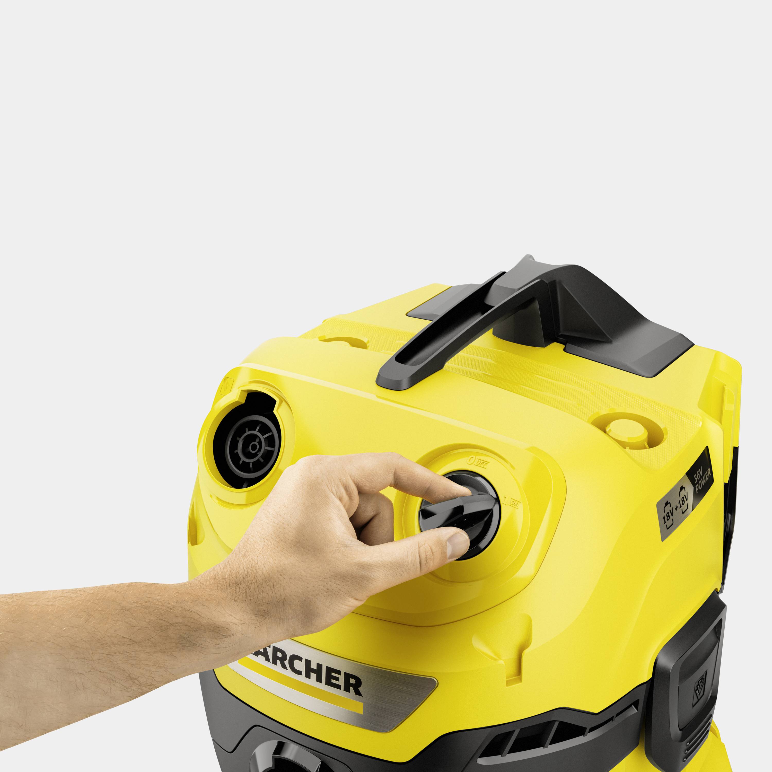 Gelbe Reinigungsmaschine mit Hand, die den Knopf dreht. Fokus auf Steuerung der Maschine.