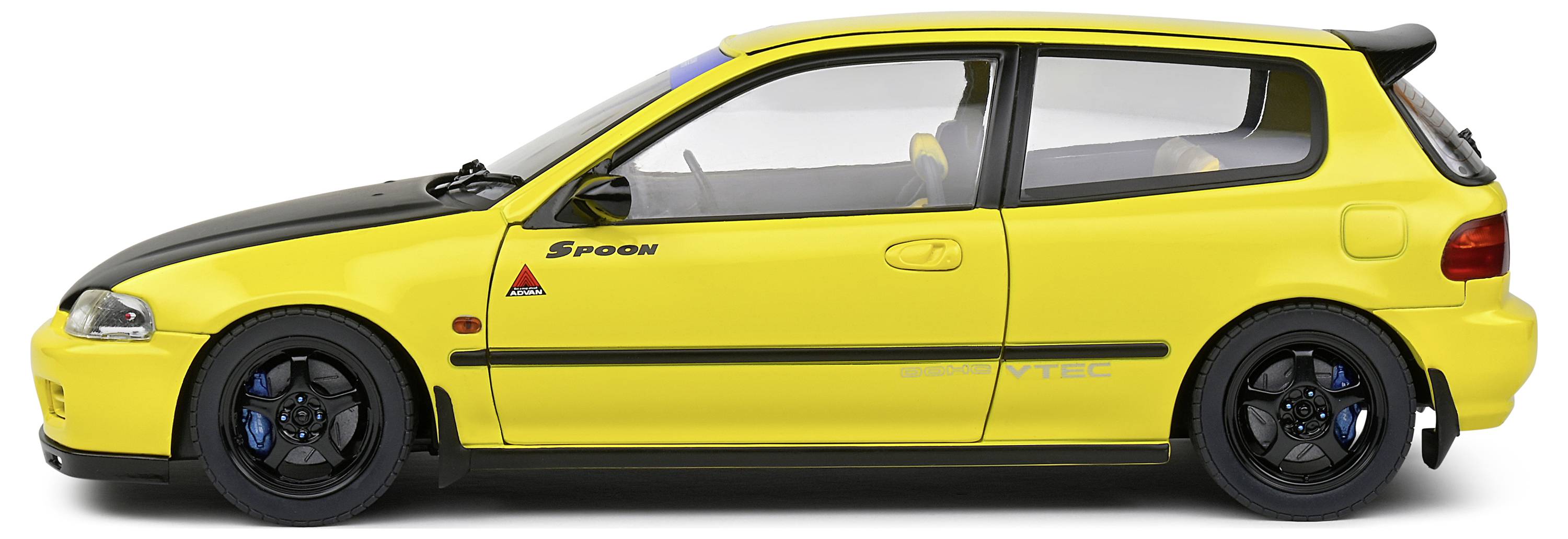 Gelbes Auto im Profil mit sportlichem Design, schwarzer Motorhaube und blauen Bremssätteln, markantes Spoiler-Detail hinten.