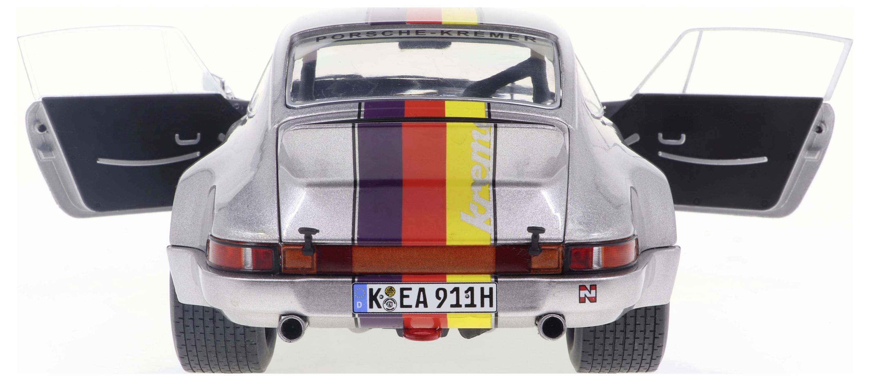 Ein silberner Sportwagen von hinten, mit geöffneten Türen und einem bunten Streifenmuster auf dem Dach und Heck, Kennzeichen 'K EA 911H'.