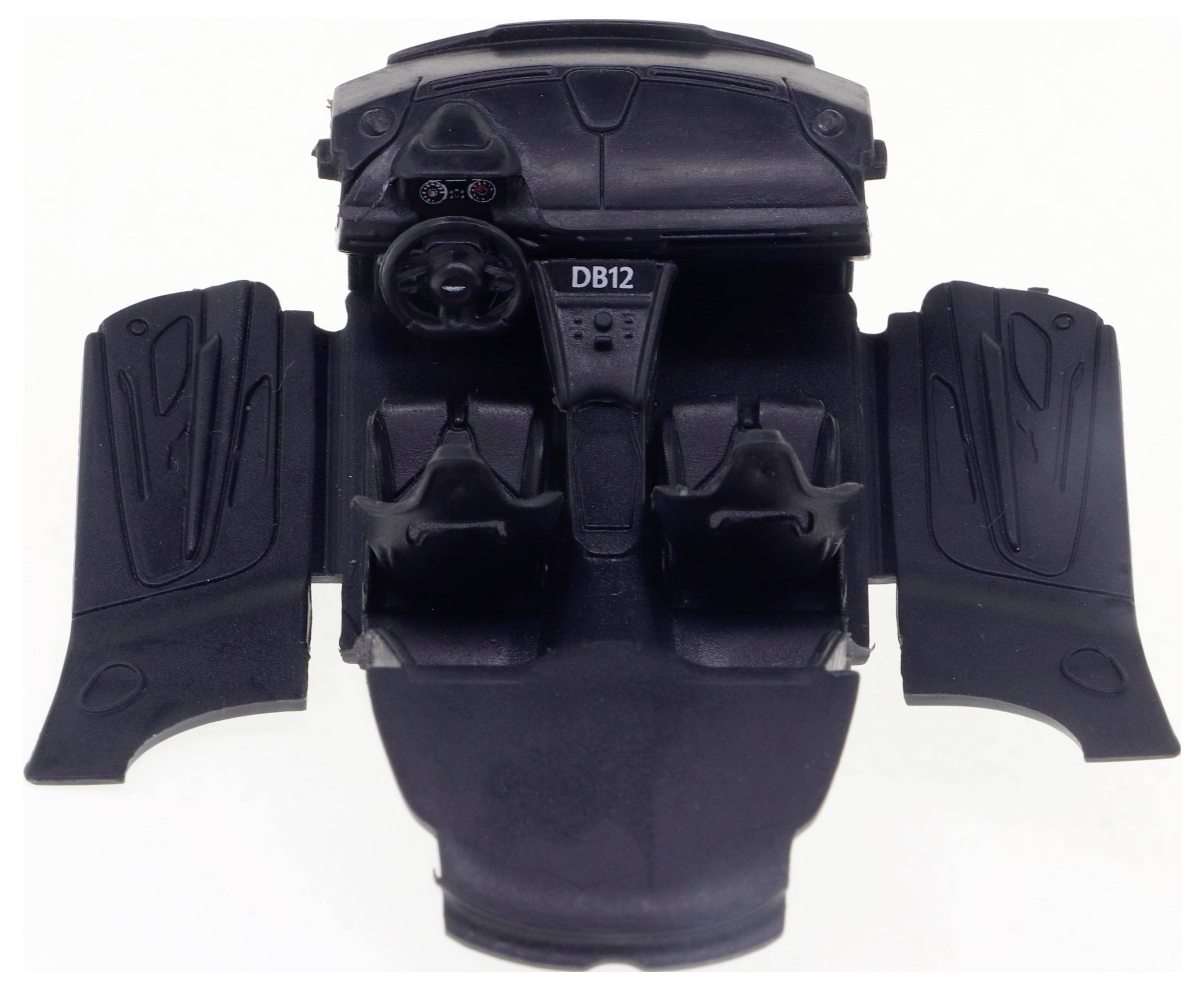 Ein schwarzes Kunststoffmodell eines Autoinnenraums mit Lenkrad, zwei Sitzen und der Aufschrift 'DB12' auf der Mittelkonsole.