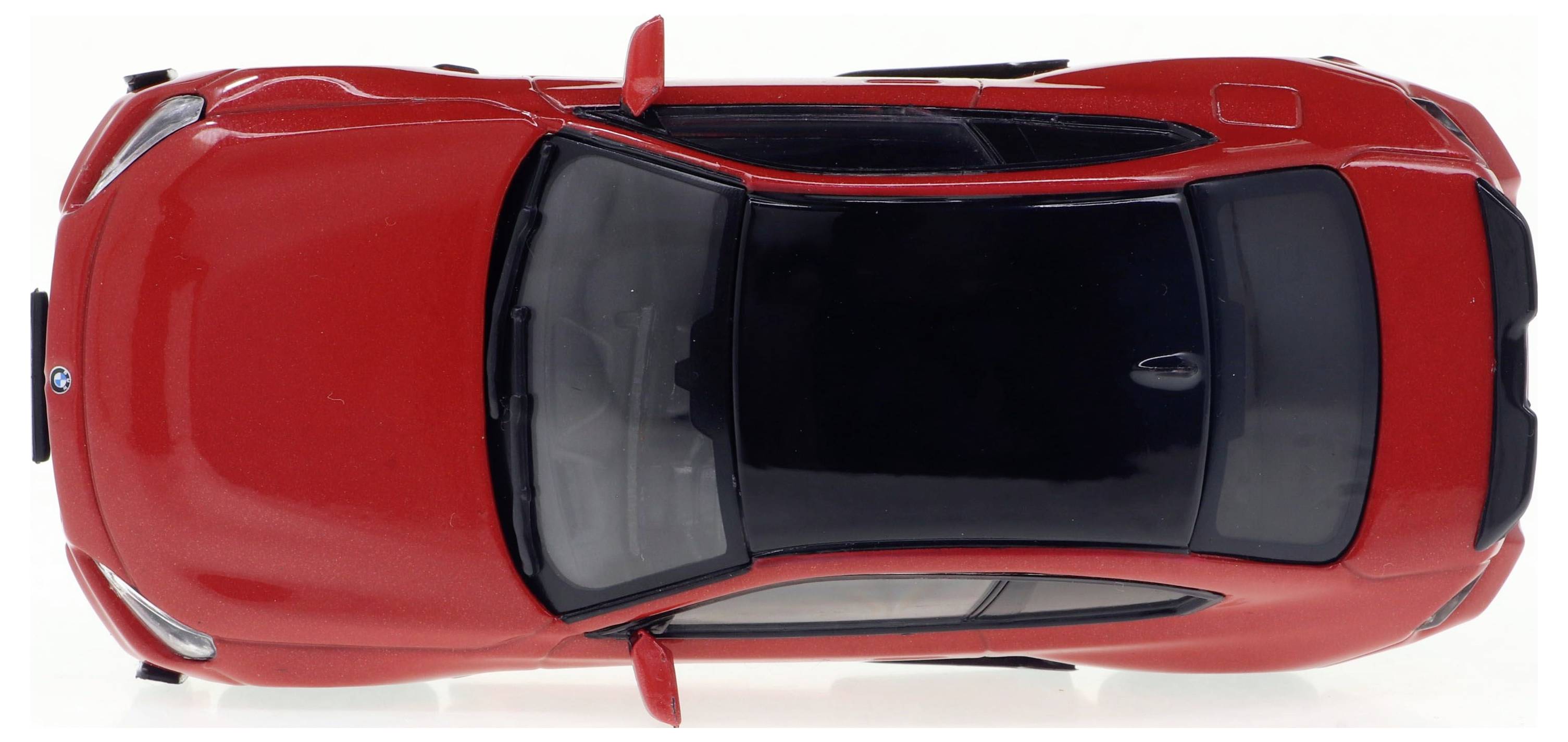 Rotes Auto von oben betrachtet, mit schwarzem Dach und Spiegeln.