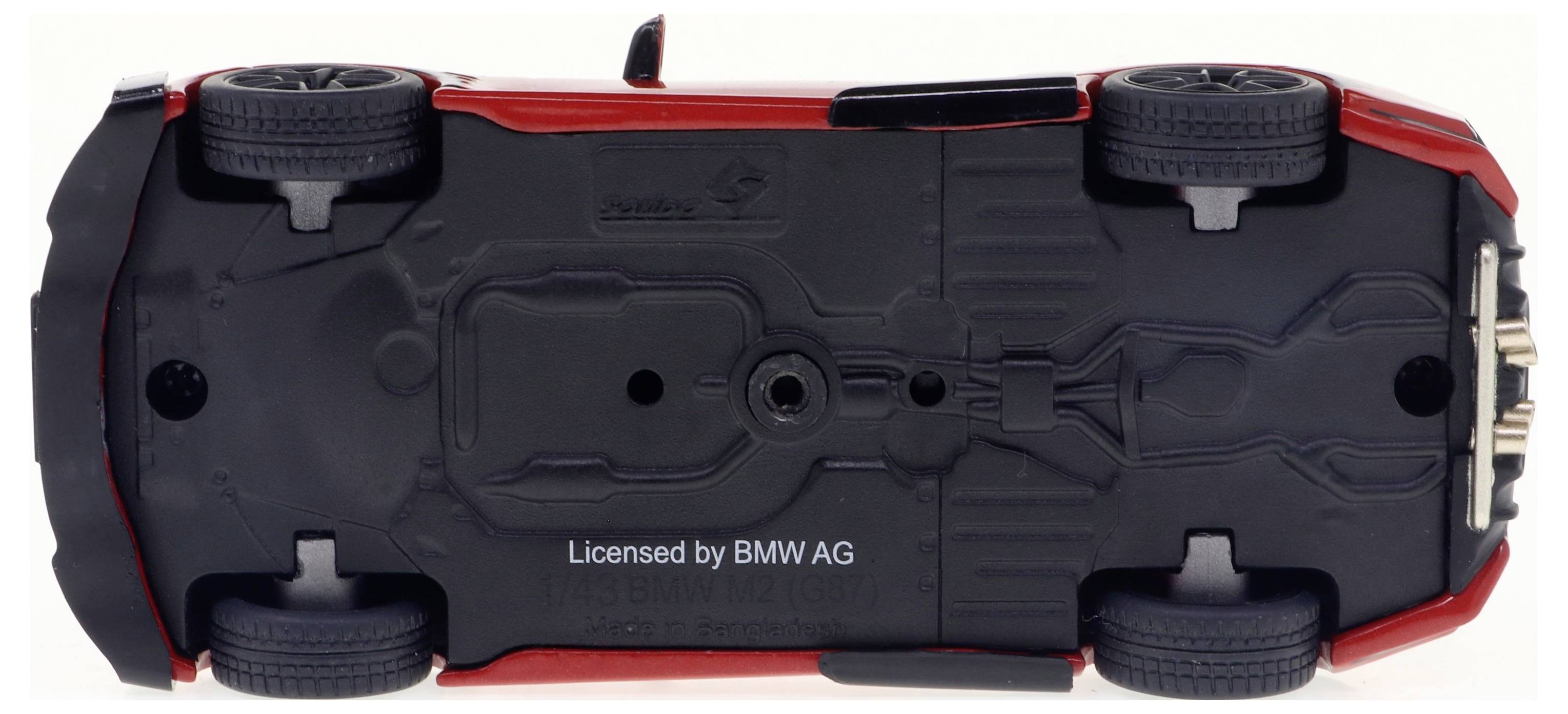 Spielzeugmodell eines Autos, das auf dem Dach liegt. Schwarzes Fahrwerk und vier Räder sichtbar. Lizenzieren durch 'Licensed by BMW AG'.