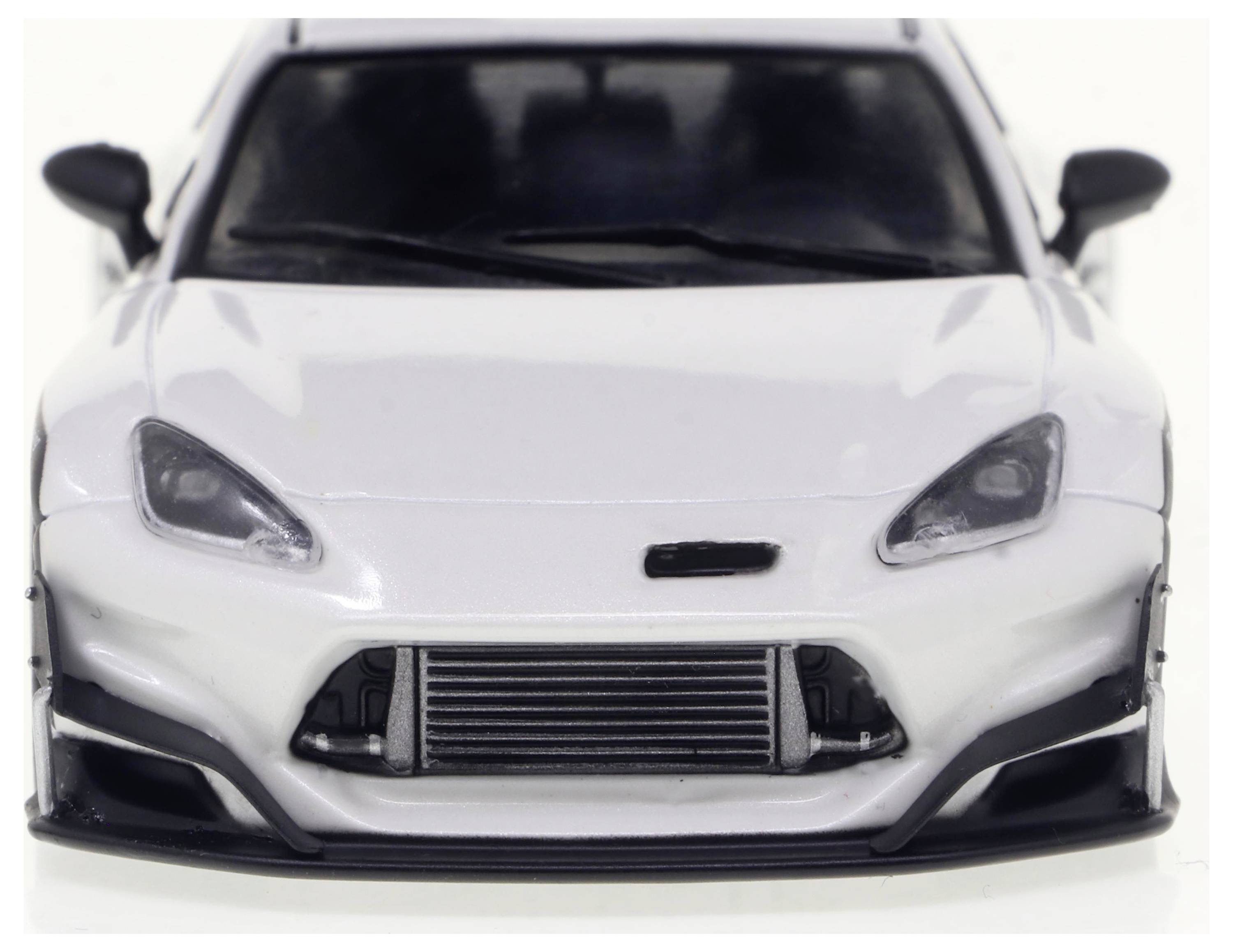 Ein weißer Sportwagen von vorne, mit schlankem Design und sichtbarem Kühlergrill.