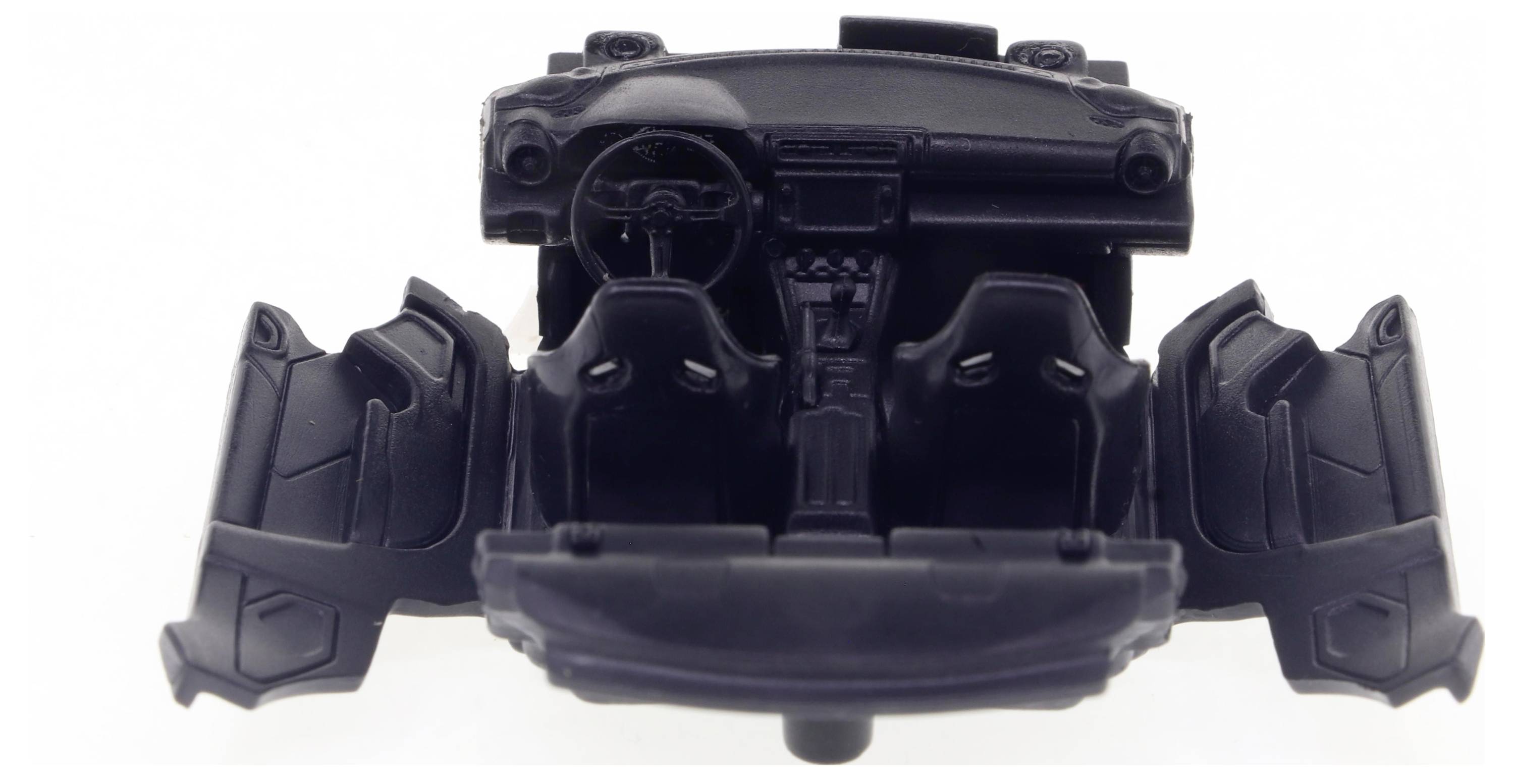 Spielzeugmodell eines schwarzen Autoinnenraums mit zwei Vordersitzen, Lenkrad und geöffneter Front- und Seitentüren.