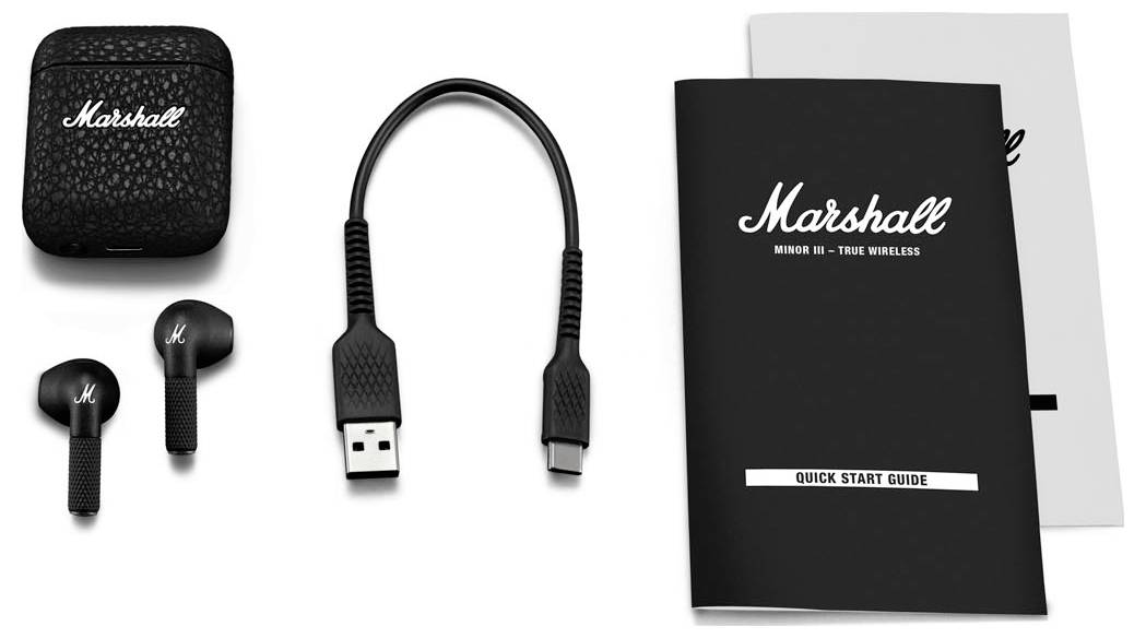 Kabellose Marshall-Kopfhörer mit Ladeetui, USB-Kabel und Bedienungsanleitung auf weißem Hintergrund.