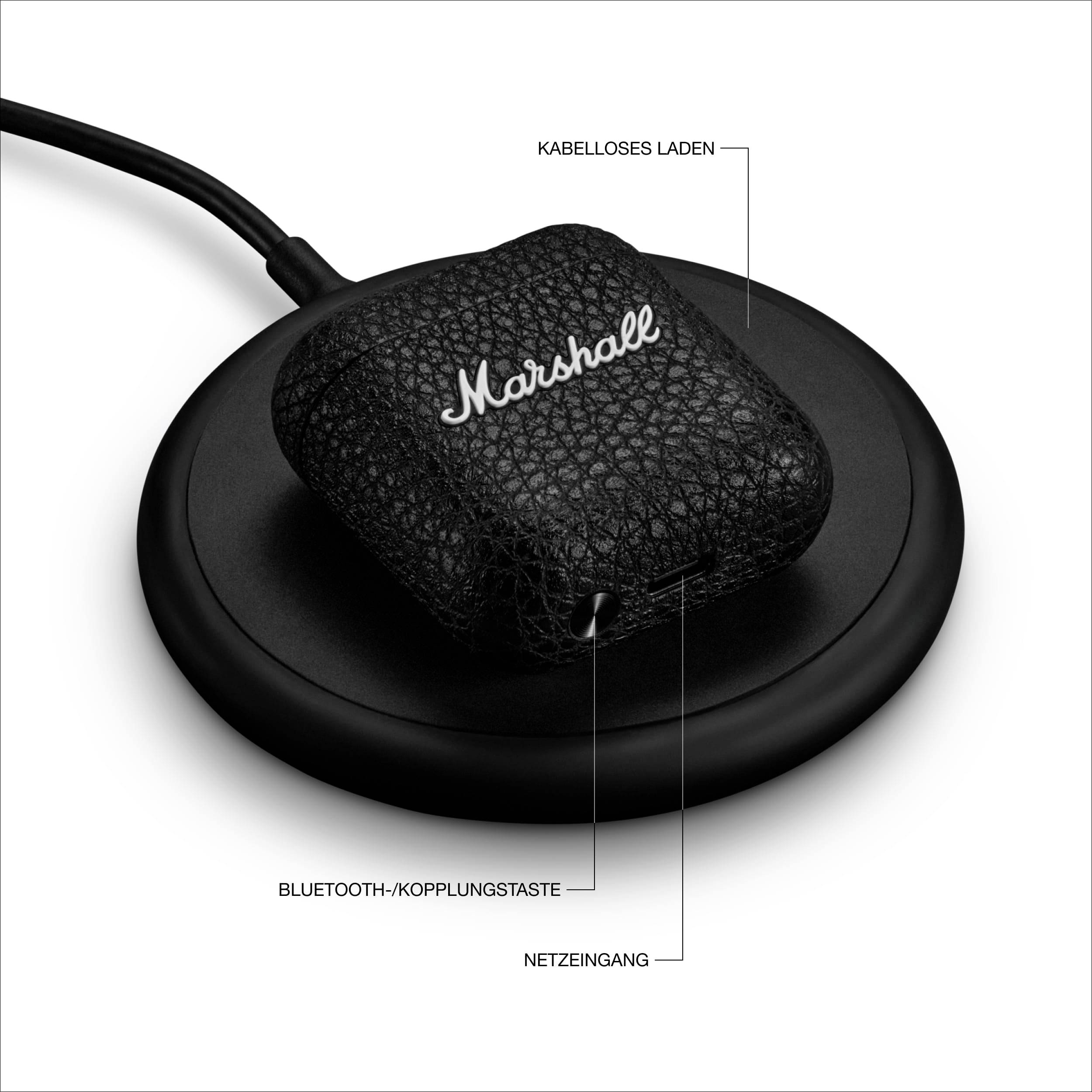 Schwarzes kabelloses Ladegerät mit 'Marshall'-Branding auf einem Lederetui. Beschriftungen: 'Kabelloses Laden', 'Bluetooth-/Kopplungstaste', 'Netzeingang'.