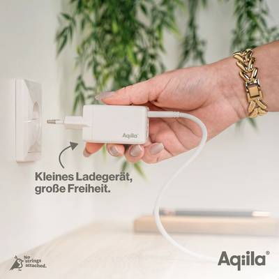 Eine Hand steckt ein Ladegerät der Marke 'Aqila' in eine Steckdose. Text: 'Kleines Ladegerät, große Freiheit'.