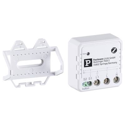 Kleines, weißes elektronisches Gerät mit Anschlüssen und Firmenaufdruck 'Paulmann Licht GmbH, Quezinger Feld 2, 31832 Springe/Germany'. Wandhalterung links daneben.