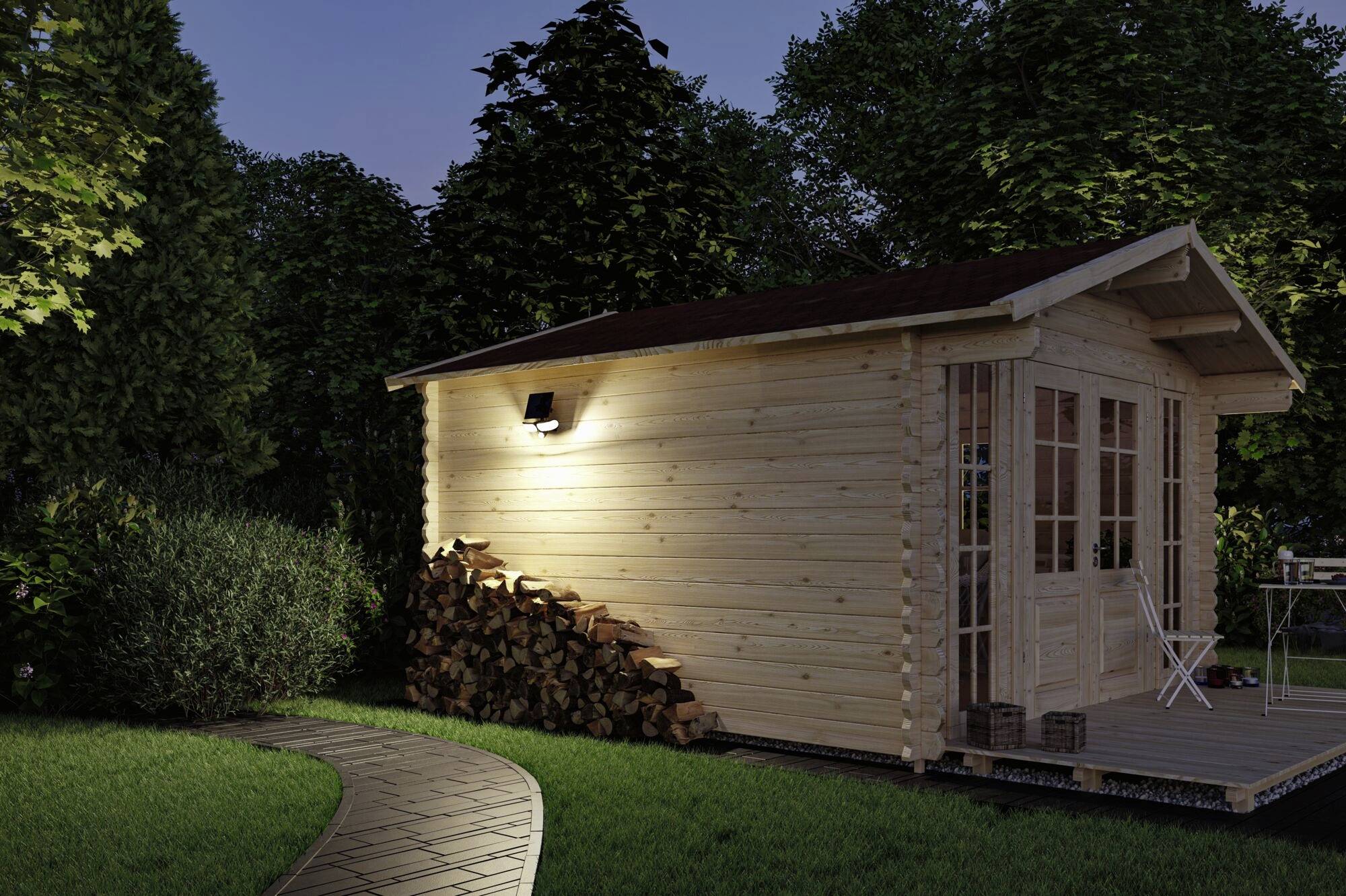 Ein kleines, beleuchtetes Gartenhaus aus Holz mit gestapeltem Holz an der Seite, umgeben von Bäumen und einem geschwungenen Weg.