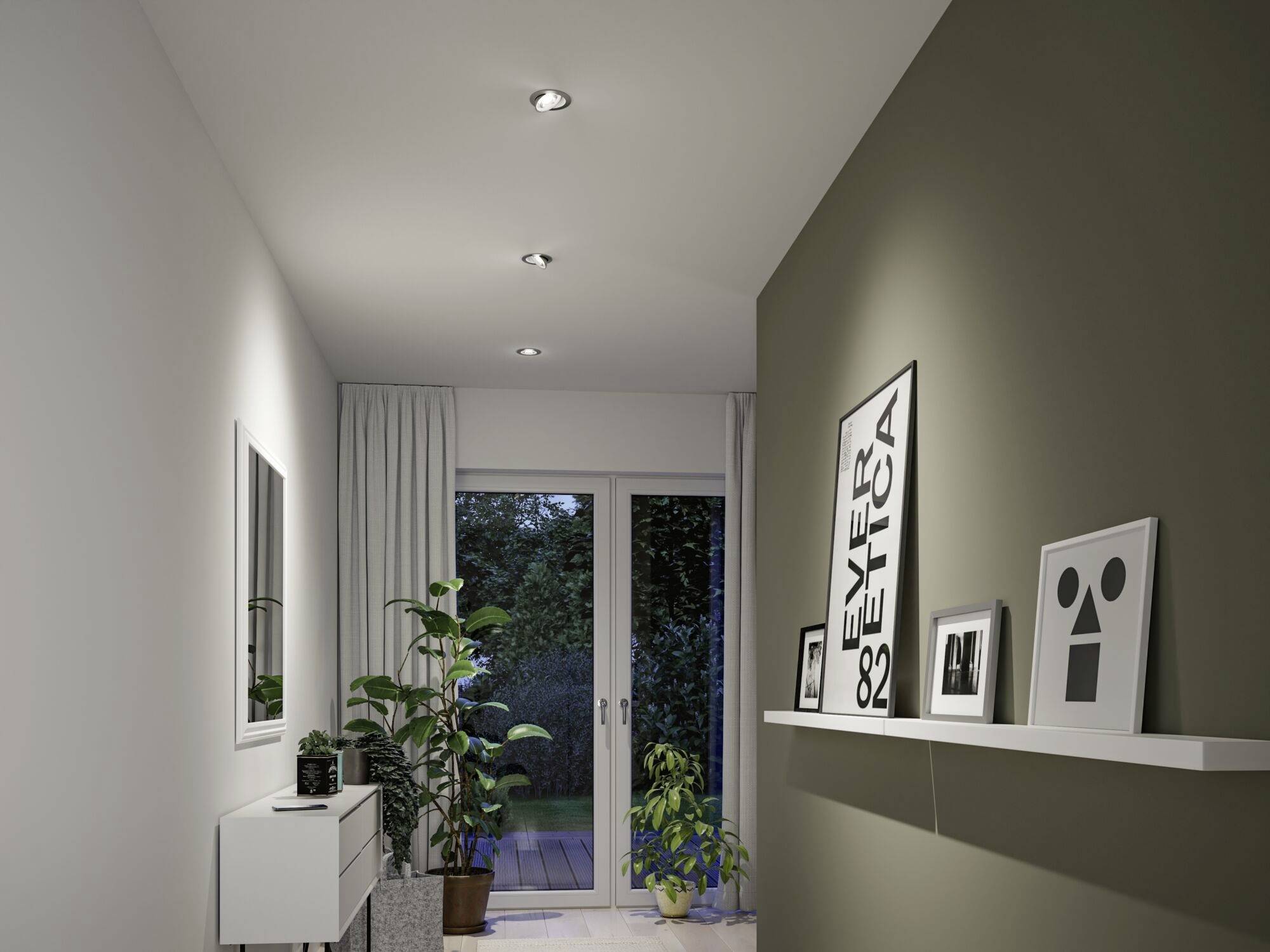 Ein schmaler Flur führt zu einer Glastür mit Blick auf einen Garten. Links stehen Pflanzen und ein weißes Sideboard, rechts hängen Bilder.