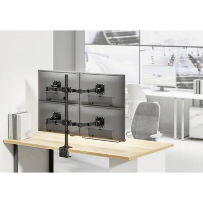Ein Schreibtisch mit einem Monitorhalterungssystem, das vier Bildschirme über der Tischplatte hält. Im Hintergrund ein modernes Büro.