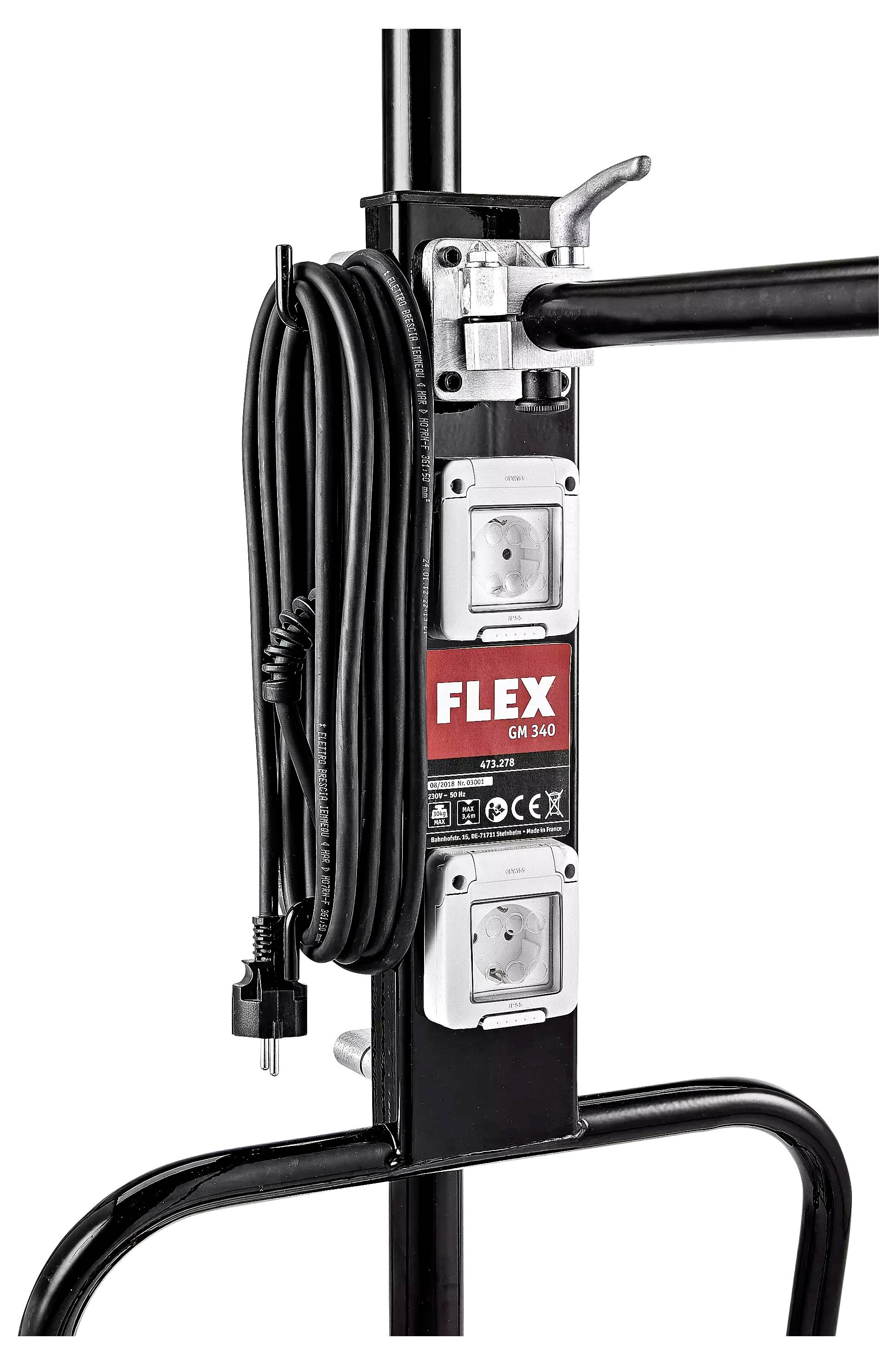 Ein schwarzer Kabelhalter mit der Marke 'FLEX' drauf. Zwei Steckdosen und ein aufgerolltes Stromkabel sind sichtbar.