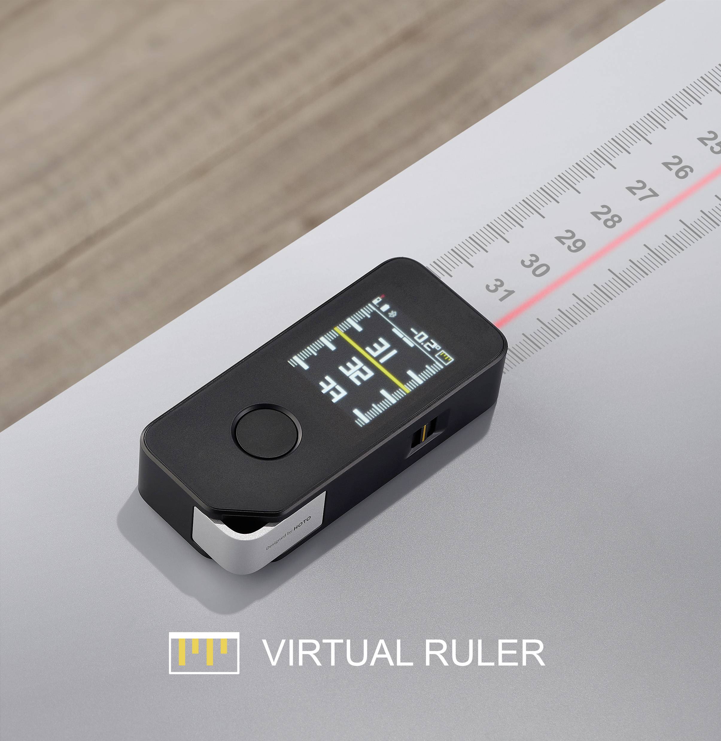 Digitales Lineal auf Tisch zeigt Messungen auf Display an. Skala auf Papier dargestellt.