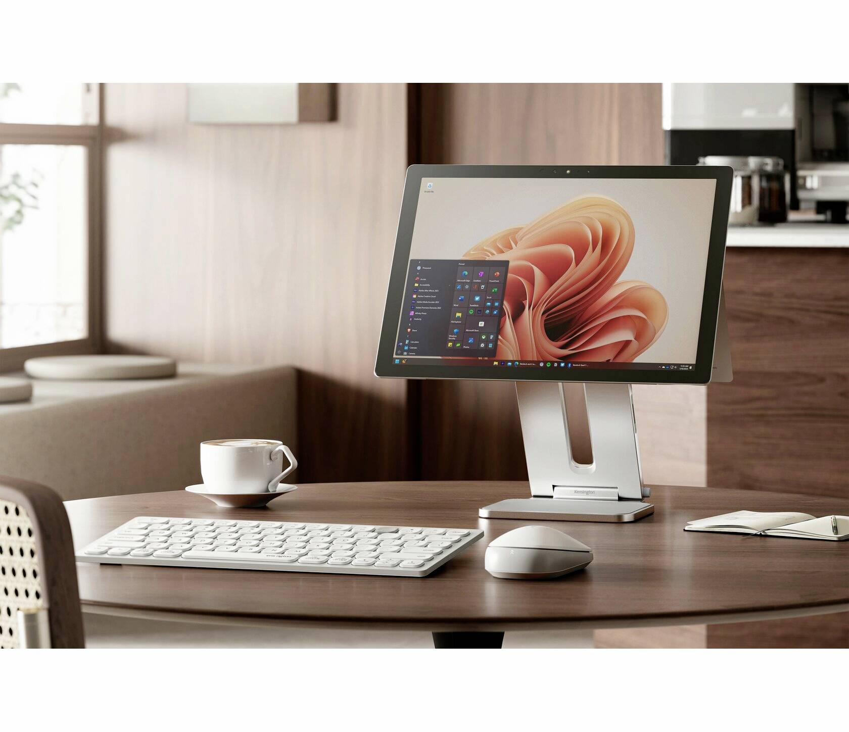 Ein moderner Computerbildschirm auf einem Tisch zeigt eine Benutzeroberfläche. Daneben stehen eine Tastatur, Maus und eine Tasse.