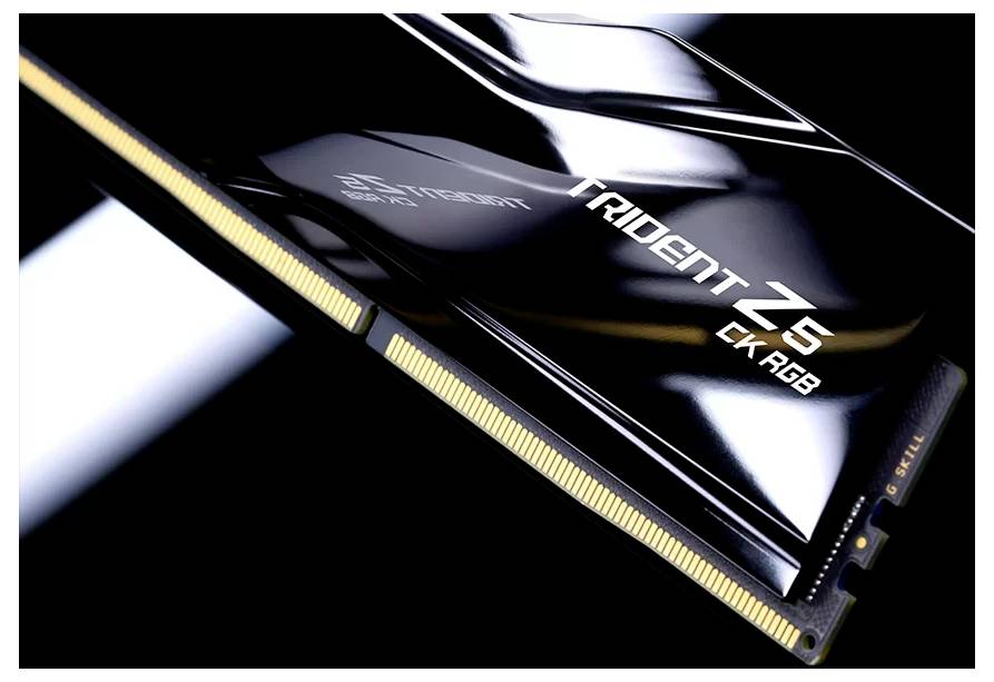 Eine Nahaufnahme eines G.Skill Trident Z5 CK RGB-Speicherriegels mit goldenen Kontakten und glänzender schwarzer Oberfläche.
