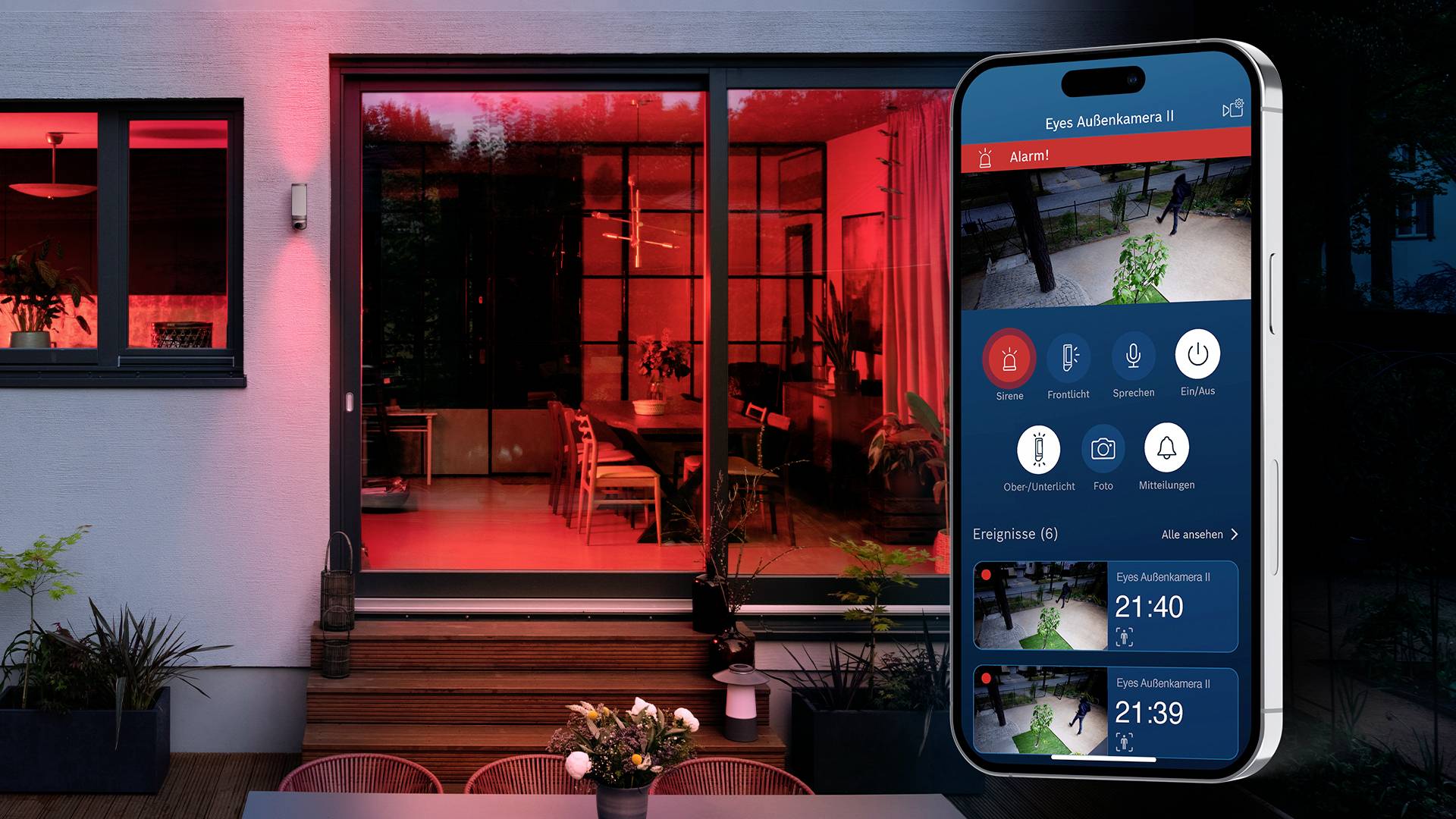 Smartphone-App zeigt Sicherheitskamerabilder und Benachrichtigungen vor einem rot beleuchteten Haus mit Glasveranda und Pflanzen.
