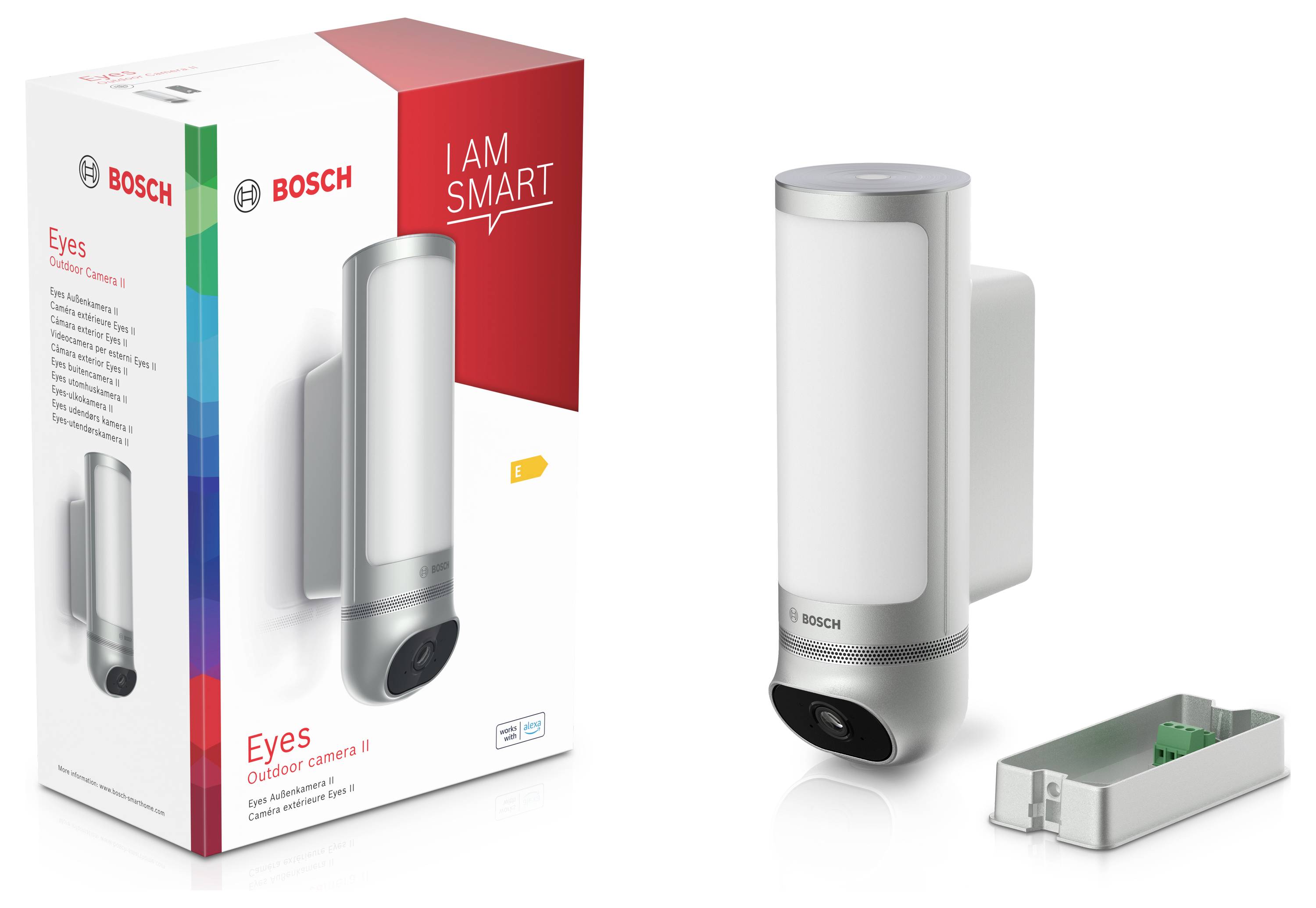 'Bosch Eyes Außenkamera' in Verpackung neben der entpackten Kamera. Moderne silberne Kamera mit Beleuchtung, Montagezubehör sichtbar.