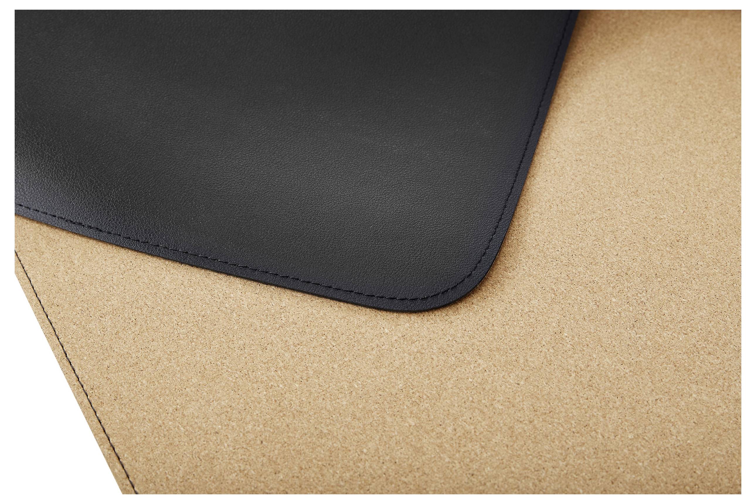 Eine Ecke einer schwarzen Matte auf einer hellbraunen Korkoberfläche.