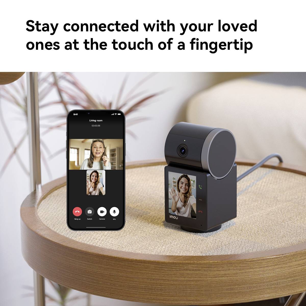Ein Smartphone zeigt ein Videoanruf mit einer Frau. Daneben steht eine smarte Kamera. Text oben: 'Stay connected with your loved ones at the touch of a fingertip'.