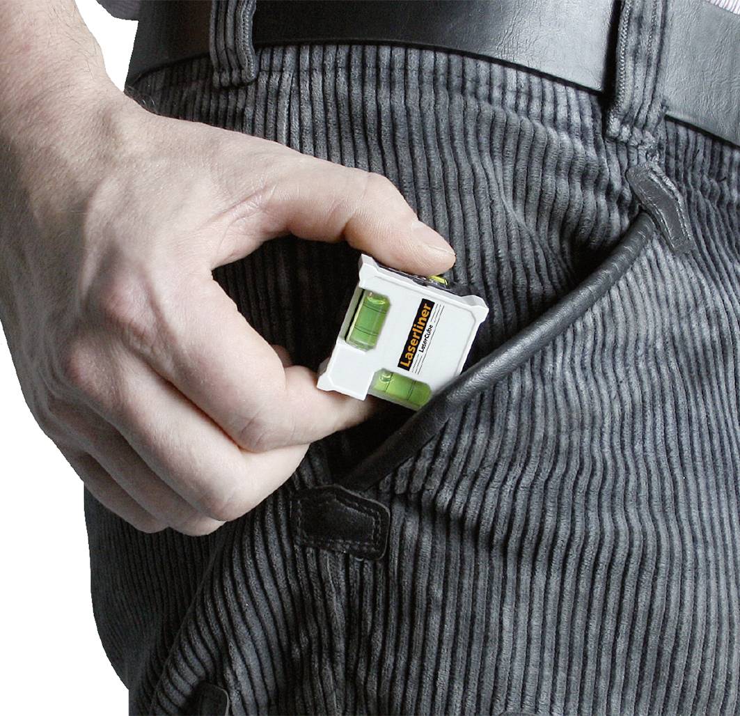 Eine Person steckt eine kleine Wasserwaage in ihre Hosentasche.