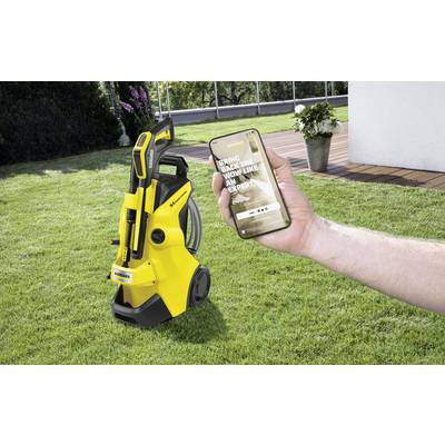 Eine Person hält ein Smartphone über einem gepflegten Rasen. Im Hintergrund steht ein gelber Hochdruckreiniger. Der Bildschirm zeigt eine Webseite.