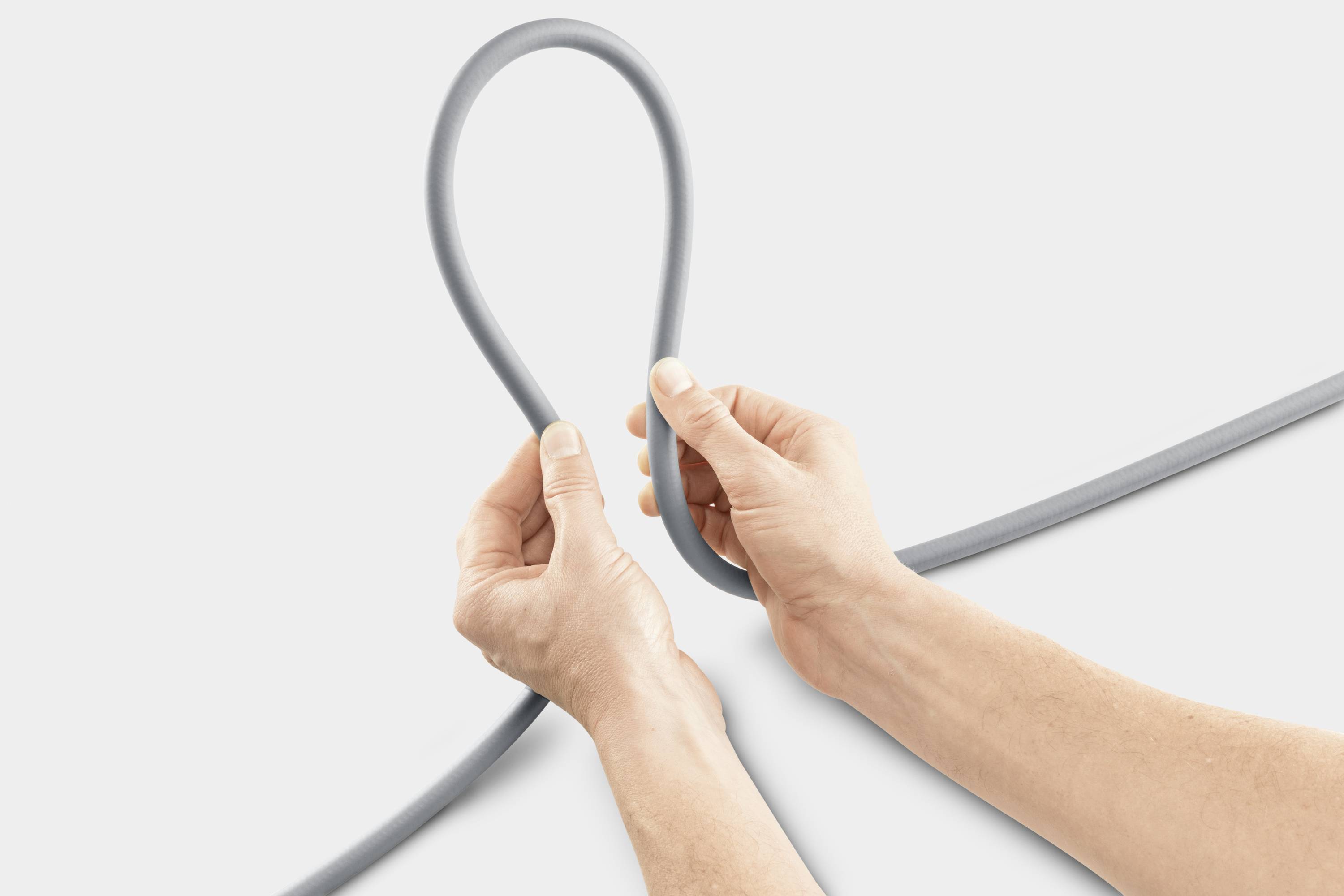 'Zwei Hände formen eine Schleife mit einem grauen Kabel vor einem neutralen Hintergrund.'