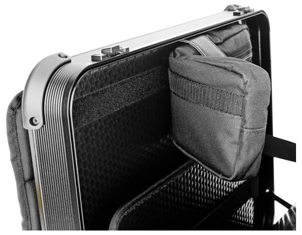 Der Innenraum eines offenen Koffers mit einem gepolsterten Trennfach und einer grauen Stofftasche.