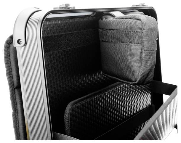 Ein offener Koffer zeigt ein gepolstertes Innenfach und eine aufgesetzte Tasche zur sicheren Aufbewahrung von Gegenständen.