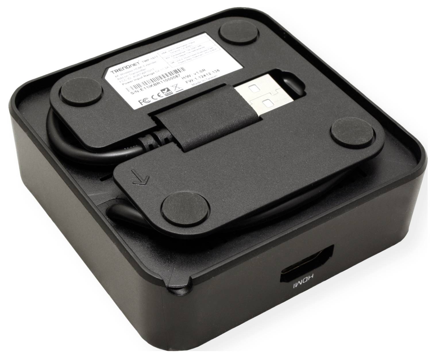 Ein schwarzes Elektronikgerät mit einem USB-Kabel und HDMI-Anschluss. Oben ein Aufkleber mit technischen Spezifikationen.