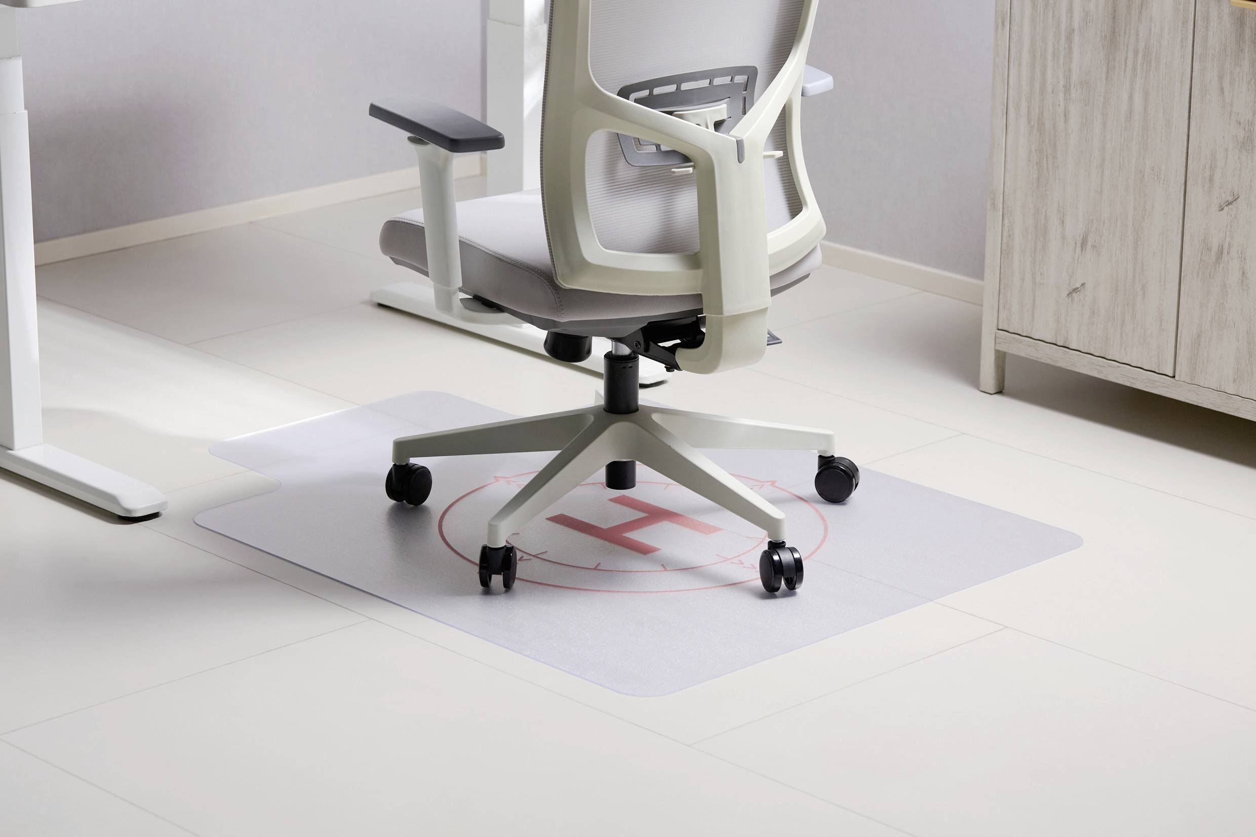 Ein Bürostuhl auf einem Schutzmatte, die den Boden schützt. Die helle, moderne Büroeinrichtung gibt einen sauberen, professionellen Eindruck.