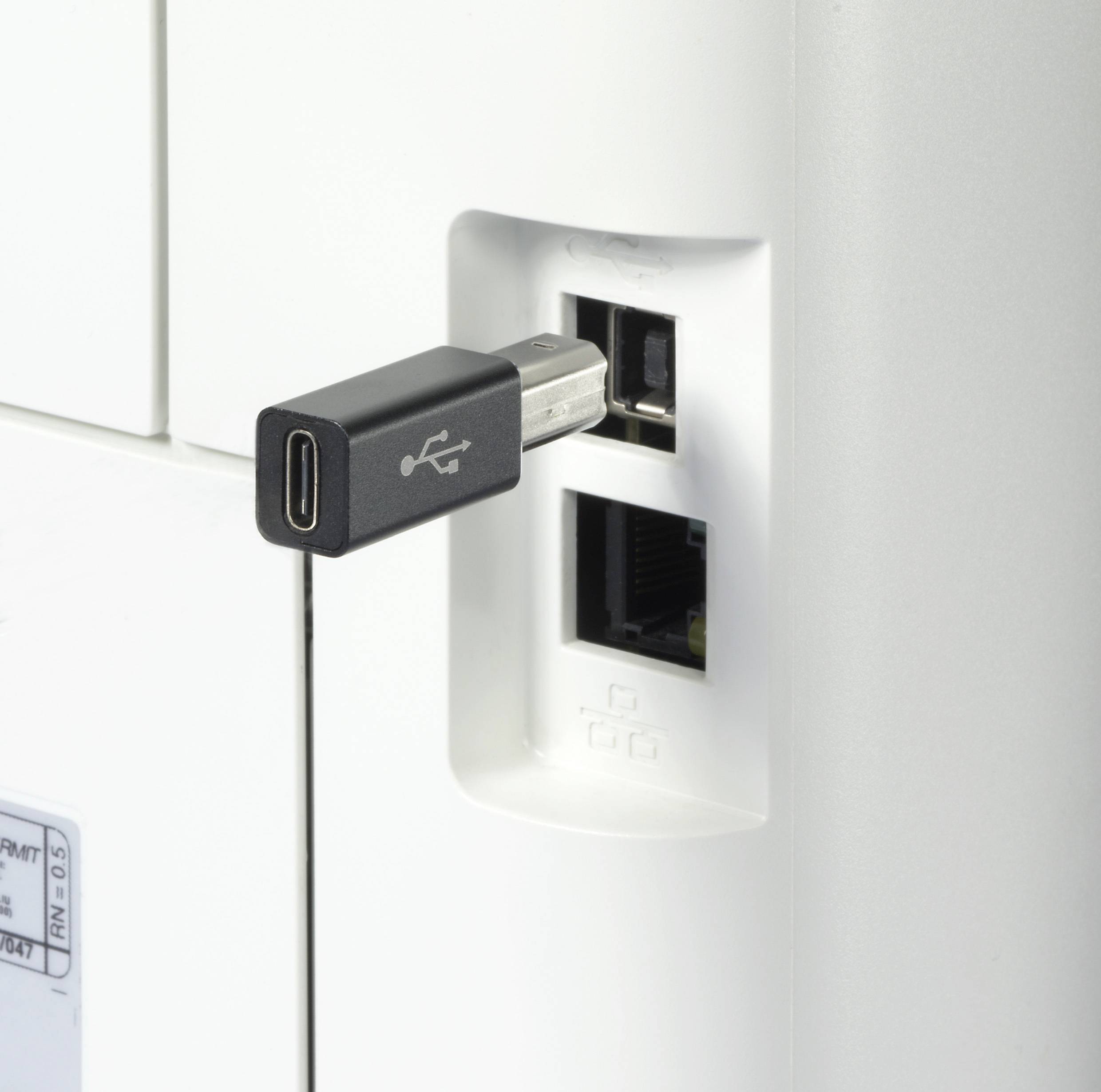 Ein USB-Stecker wird in einen USB-Anschluss eines elektronischen Geräts gesteckt. Darunter befindet sich ein Ethernet-Anschluss.