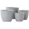 Vier graue Pflanzentöpfe in unterschiedlichen Größen stehen nebeneinander auf einer weißen Fläche. Sie haben ein schlichtes, geripptes Design.