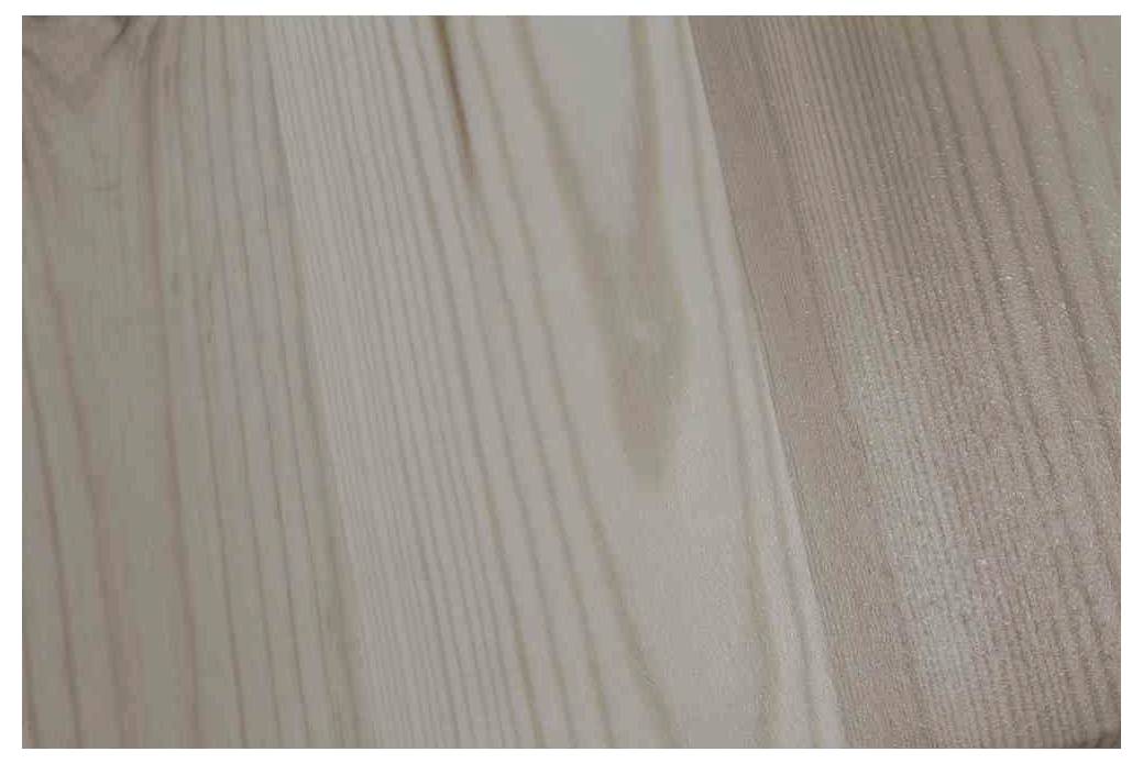 Nahaufnahme einer holzartigen Oberfläche mit feiner Maserung und einem sanften, matten Glanz.