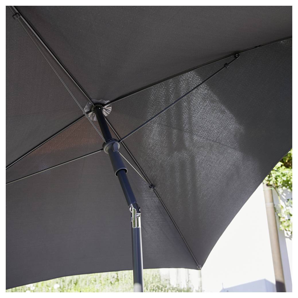 Ein großer grauer Sonnenschirm erstreckt sich über einem Außenbereich. Die Sonne scheint leicht durch den Stoff des Schirms.