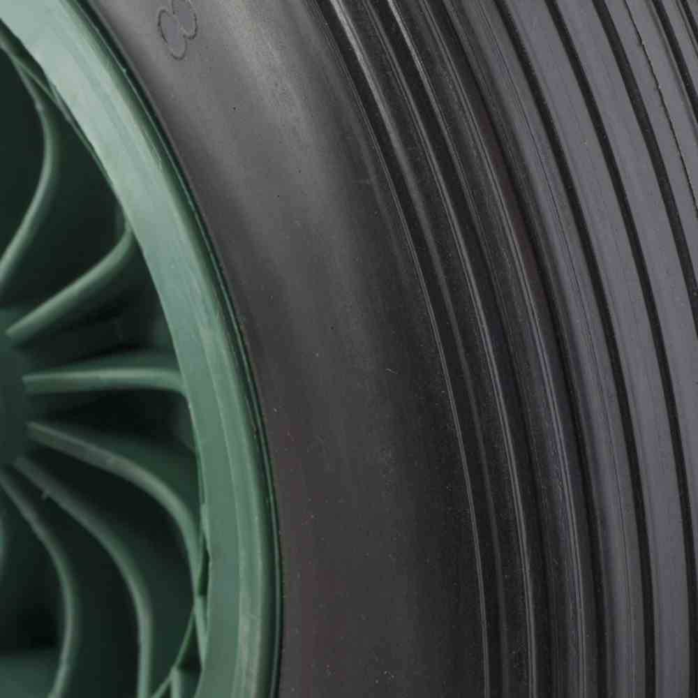 Nahaufnahme eines grünen Rades mit schwarzem Reifen; zeigt die Textur von Radnabe und Lauffläche.