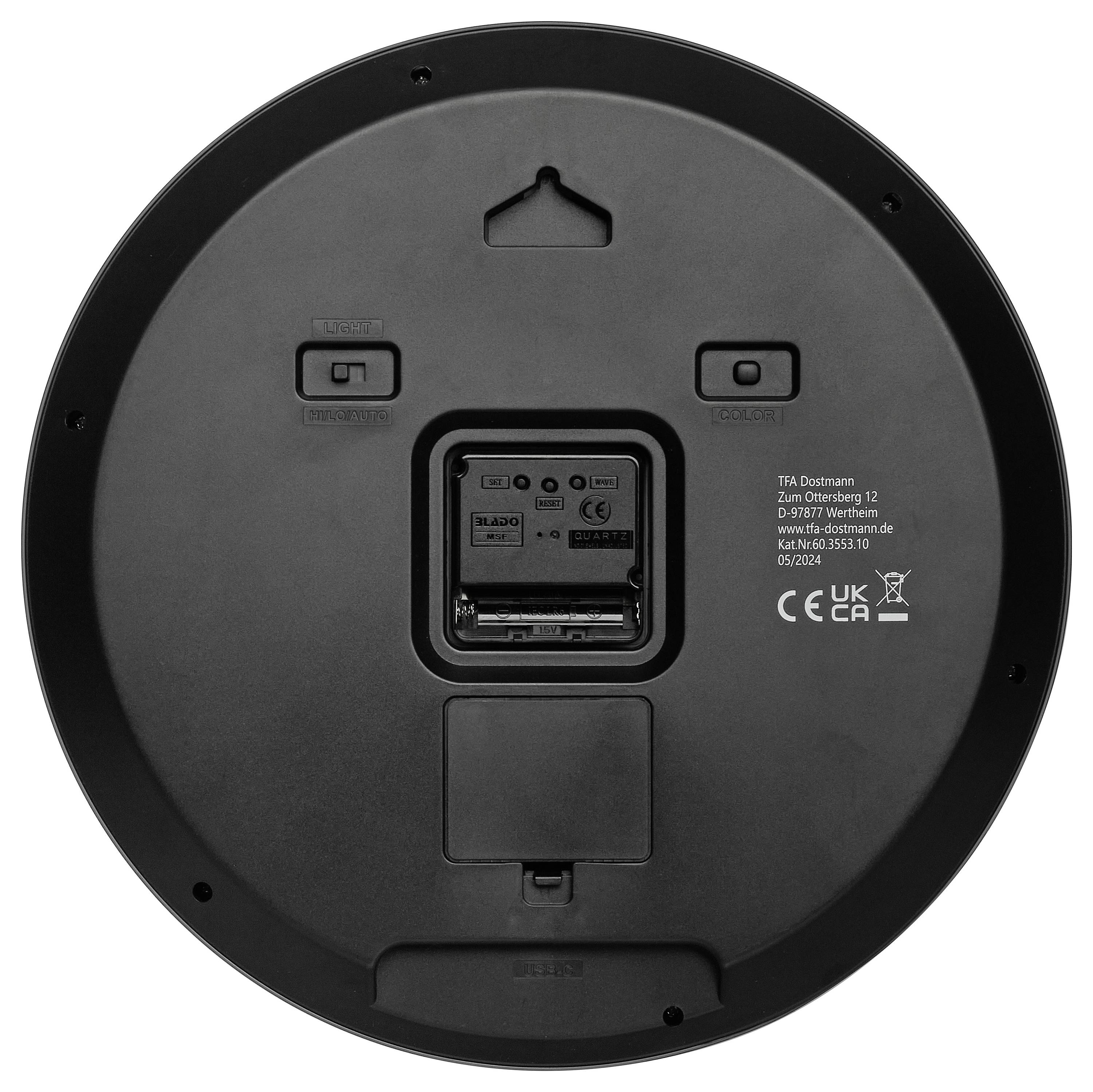 Die Rückseite eines runden, schwarzen Geräts mit Batteriefach und Knöpfen für Farbauswahl und anderen Funktionen.