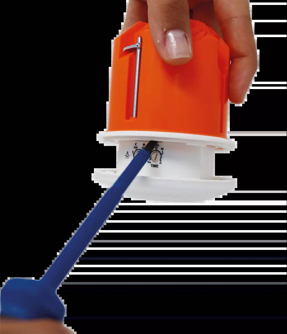 Eine orange Kunststoffdose mit einem blauen Stab zum Drehen. Die Skala zeigt Zahlen zur Einstellung der Zeit. Hand bewegt den Stab.