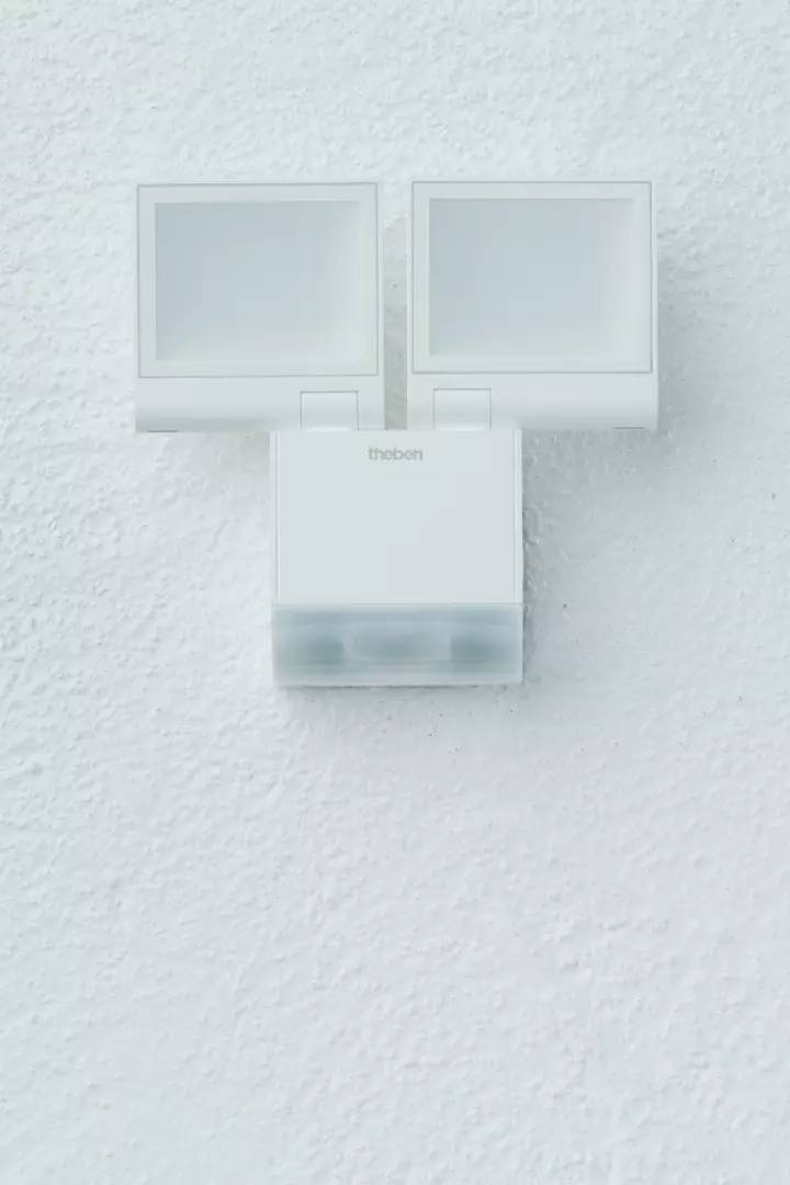 Wandmontierter weißer Bewegungsmelder mit zwei Sensoren, der Innen- oder Außenbewegungen erkennt.