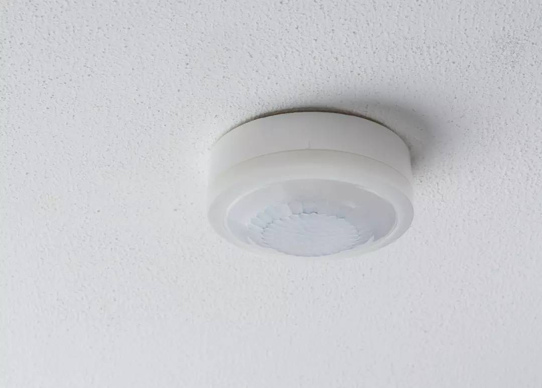 Bewegungsmelder an der weißen Decke montiert.