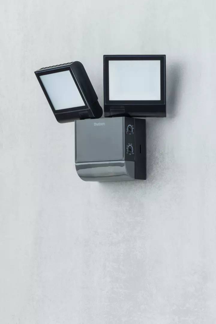 Außenleuchte mit zwei quadratischen LED-Panels und dunkelgrauem Gehäuse an einer hellen Wand montiert.