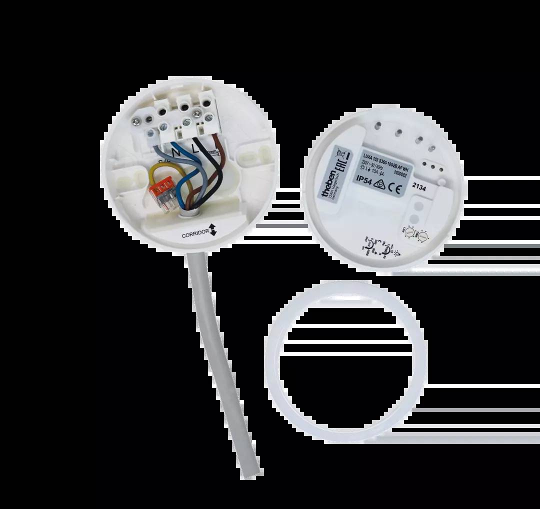 Geöffnete weiße Kunststoffdose mit elektrischen Anschlüssen und Kabeln. Daneben liegt ein abnehmbarer Deckel mit Beschriftungen und Zeichen.