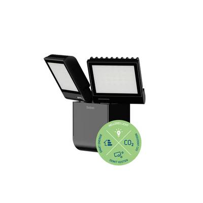 Ein LED-Strahler mit zwei Leuchtflächen, daneben ein Kreis mit Piktogrammen und Text: 'Spart Energie, Helleres Licht, Reduziert CO2, Senkt Kosten'.