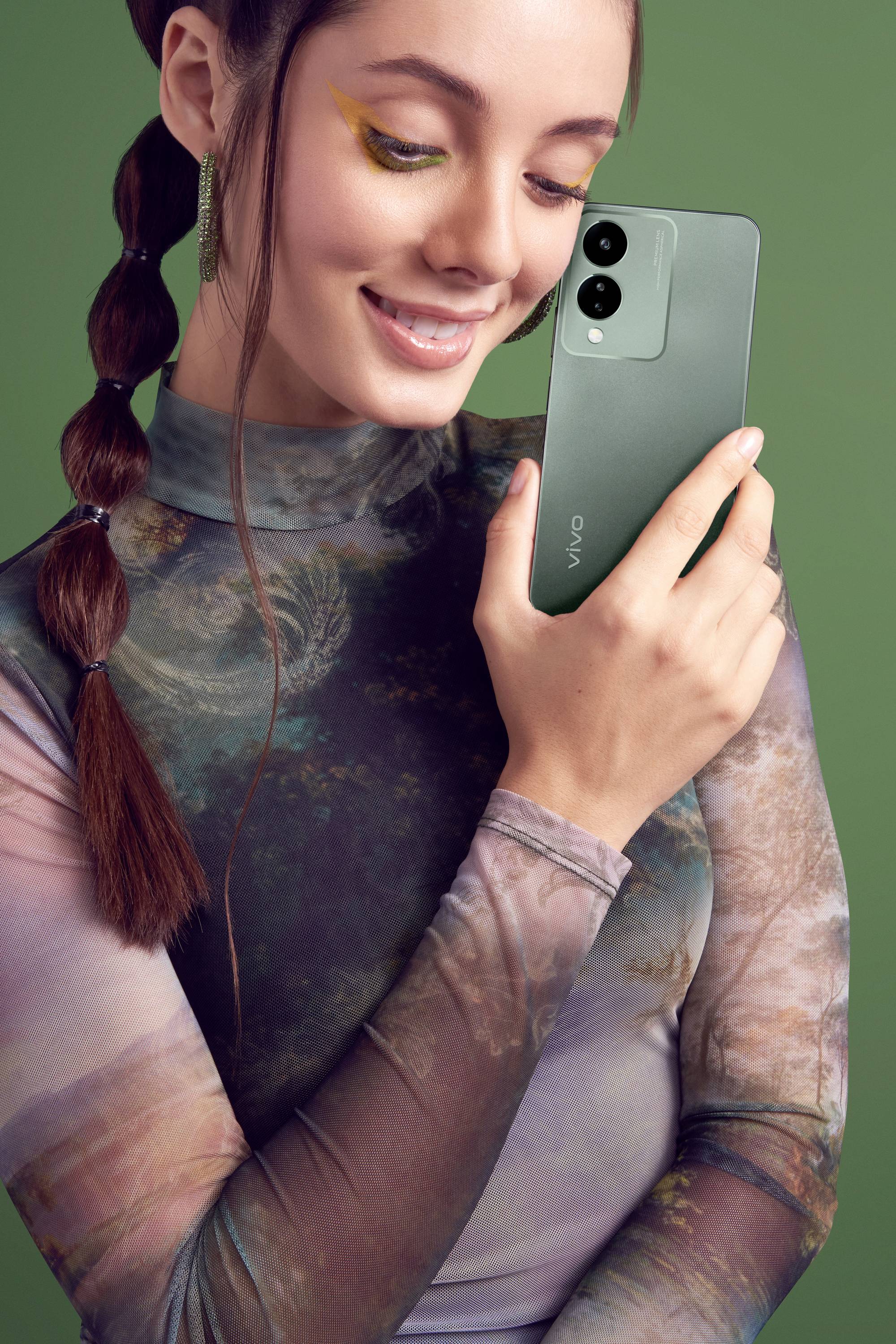 Frau mit buntem Kleid hält ein grünes Smartphone und lächelt. Hintergrund in Grün.