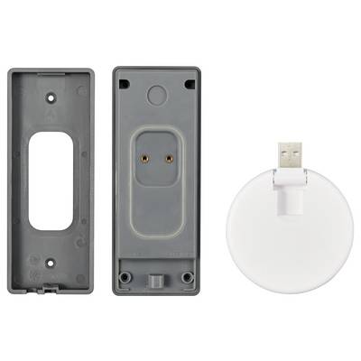 Graues Plastikgehäuse in zwei Teilen neben einem weißen, runden USB-Ladedock. Die Rückseite zeigt Metallkontakte im Inneren.