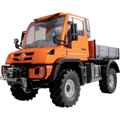 Ein orangefarbener Lastwagen mit großer Bodenfreiheit und robusten Reifen, geeignet für den Offroad-Einsatz.