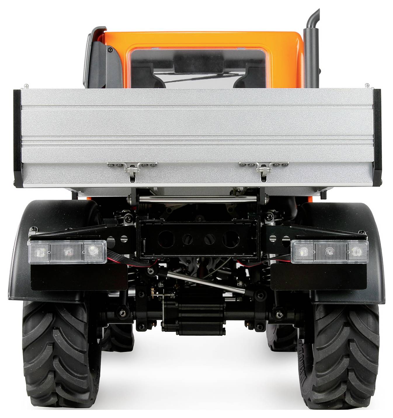 Ein orangefarbener Traktor von hinten, mit großen Rädern und einer silbernen Ladefläche. Die Fahrerkabine ist teilweise sichtbar.