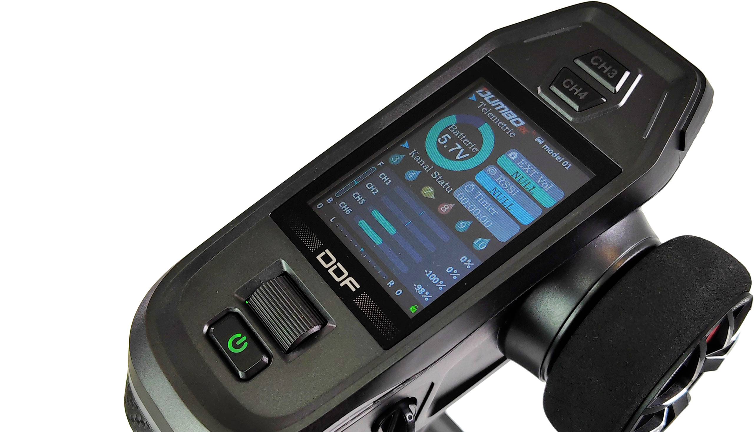 Fernsteuerung mit Bildschirmdisplay zeigt Ladestand, Kanaleinstellungen und andere Geräteinformationen. Links Power-Taste, rechts Steuerungsrad.