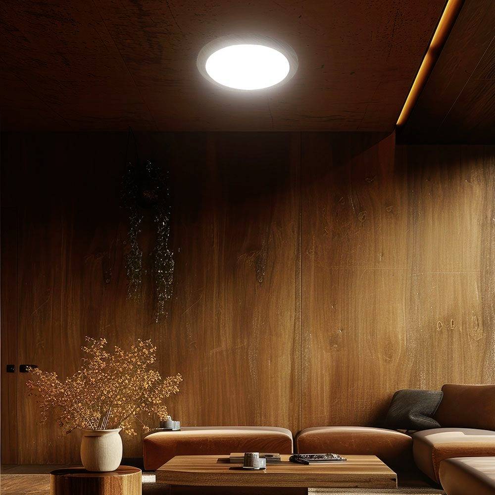 Holzgetäfelter Raum mit modernem Sofa, rundem Couchtisch und dekorativer Vase; betont durch warmes, weiches Deckenlicht.