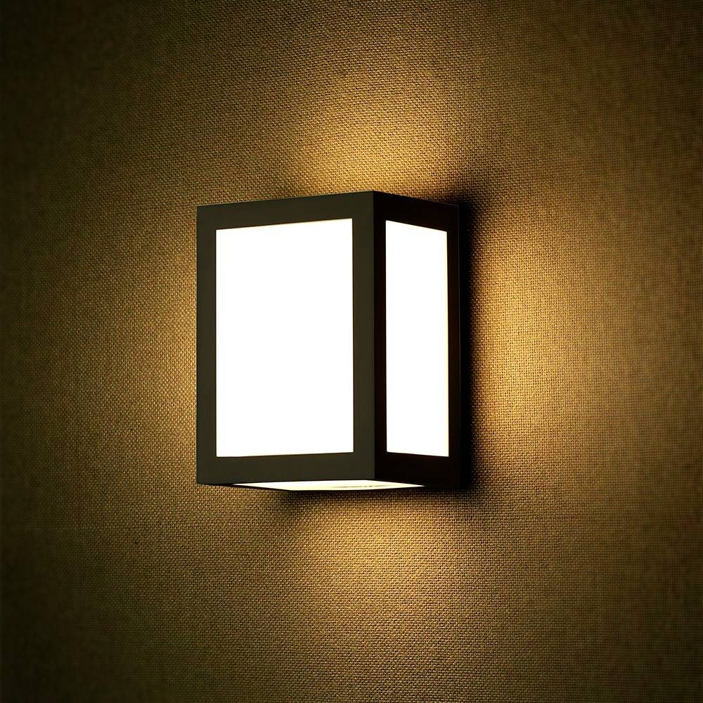 Wandlampe mit rechteckigem, modernem Design beleuchtet eine strukturierte Wand in warmem Licht.